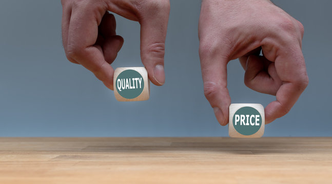 Symbol for choosing quality instead of a cheap price. Two Hands hold two dice with the words "quality" and "price". The dice with the label "quality" is chosen.