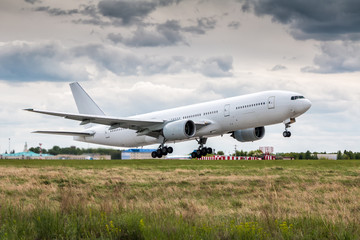 Fototapeta na wymiar White wide-body passenger airplane in the air on take-off in cloudy weather