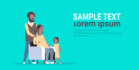 Pregnant woman with husband and daughter