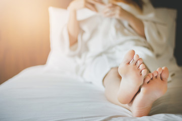 Closeup of foot with young asian woman on bed