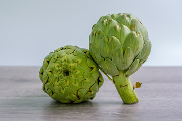 Fototapeta premium artichokes on grey background. fresh organic artichoke flower