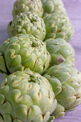Obraz premium artichokes on grey background. fresh organic artichoke flower