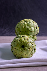 Fototapeta premium artichokes on grey background. fresh organic artichoke flower