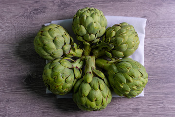 Fototapeta premium artichokes on grey background. fresh organic artichoke flower