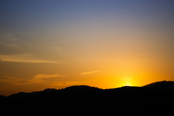 Beautiful sunset along the mountain made beautiful warm and blue sky.  Peaceful landscape and sky.
