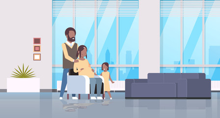 pregnant woman with husband and daughter happy african american family at home girl touching mother belly pregnancy motherhood concept living room interiorfull length horizontal