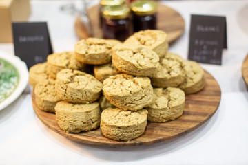 Home made scones served on a wooden plate on the table close up.