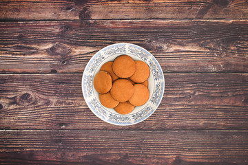 Cookies in plate on wooden background