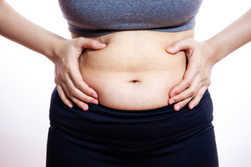 Unhealthy fat women catching on her belly close up.  isolated on white background.