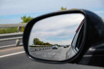Fototapeta premium look in the rear view mirror of a car