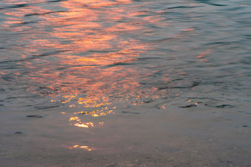 Wavy water surface with glittering orange sun light. (6)