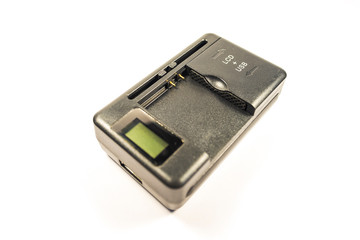 Universal charger for lithium-ion battery made of black plastic with adjustable contacts and usb output on a white background