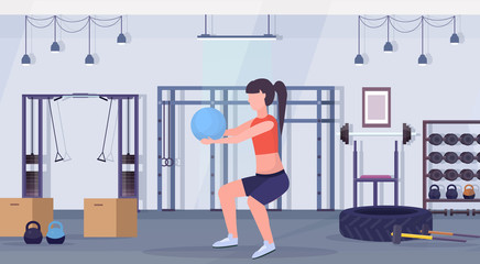 Fototapeta na wymiar sporty woman doing squat exercises with fitness ball girl training aerobic workout healthy lifestyle concept modern gym interior flat horizontal