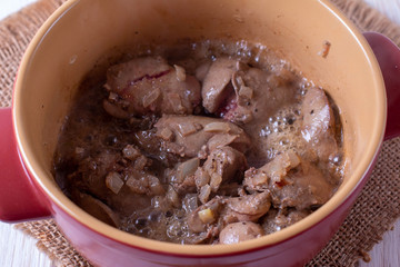 Chicken liver stew with vegetables in a pan on a table