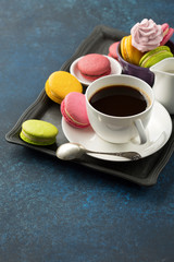 Cup of coffee and sweets on table