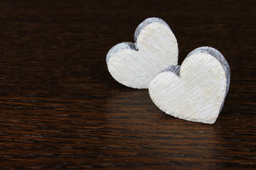 Decorative wooden hearts on dark wooden background