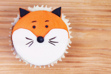 Decorated cupcake on wooden background