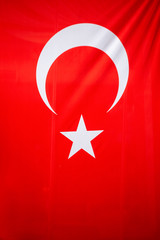Flag of Turkey on wooden plate background. Grunge Turkish flag texture, a red field with a white star and crescent slightly left of center.