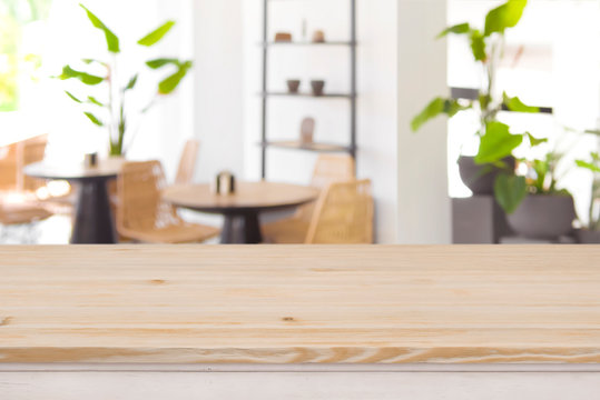 Wood table top on defocused restaurant or coffee shop background