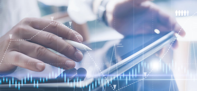 Businessman holding tablet on hand and using electronic pen while working at office.Concept of digital diagram,graph interfaces,virtual screen,connections icon.Wide format
