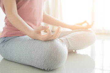 Close up hand and half body of healthy woman sit in lotus Yoga position.Young healthy woman sitting...