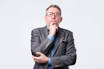 Senior man in suit and glasses doubt expression