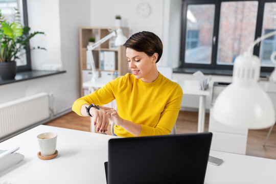 business, technology and time management concept - happy smiling businesswoman using smart watch at office - Powered by Adobe