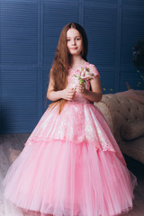 Cute adorable baby girl in elegant wedding dress indoors posing and looking at camera. Childhood, fashion kids concept