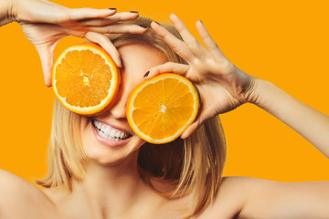 beautiful stylish girl holding orange smiling and looking at camera isolated