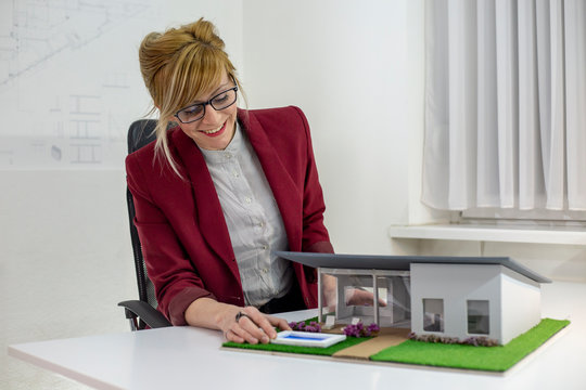 A female architect looking at a model house