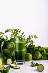 Detox cucumber smoothie in glass at wooden white background.