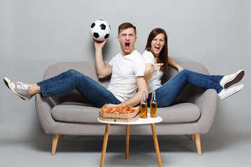 Screaming crazy couple woman man football fans cheer up support favorite team with soccer ball,...