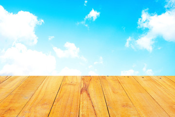 Old Wooden table with blue sky white cloud background.