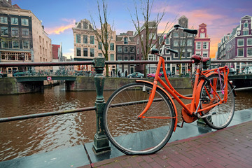 Orange bike along the canals in Amsterdam the Netherlands