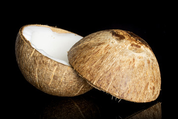 Group of two halves of fresh bio coconut one sliced isolated on black glass