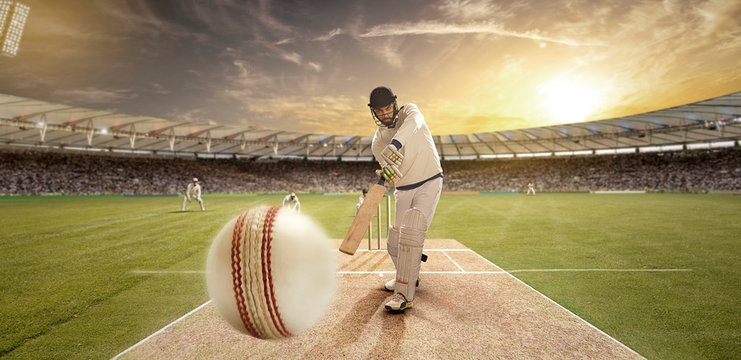 Young sportsman hitting the ball while batting in the cricket field	