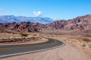 A road through the Nevada desert, with a blue sky overhead
