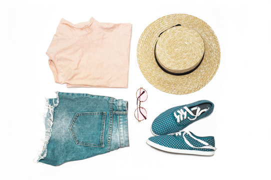 Fashionable set of summer clothes and accessories on a white background. T shirt, denim shorts, hat, moccasins and sunglasses. Top view. Flat lay