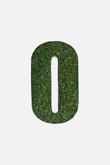 top view of cut out O letter on green grass background isolated on white