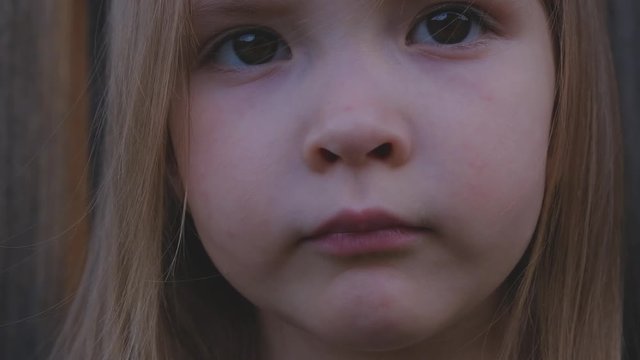 Close-up portrait of a beautiful little girl posing outdoors
