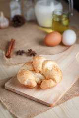 Croissant on wooden cut board on table wood and fabric select focus shallow depth of field