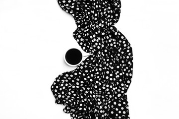 A cup of coffee and a piece of cloth. Black and white color. Flat lay. Top view