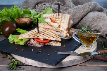sandwich with meat and fresh vegetables on a wooden table, rustic background