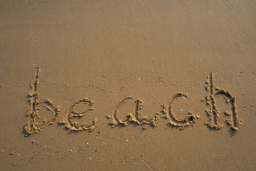 Vacation on the sand beach concept. Beach words written into the sand on the beach at Rayong, Thailand.