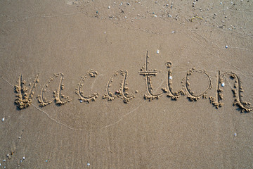 Vacation on the sand beach concept. Vacation Time words written into the sand on the beach at Rayong, Thailand
