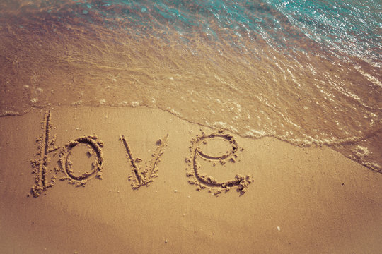 Love and Valentine concept. Love words written into the sand on the beach at Rayong, Thailand