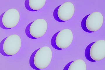 White chicken eggs  with empty space, on a pink purple background. Abstract image