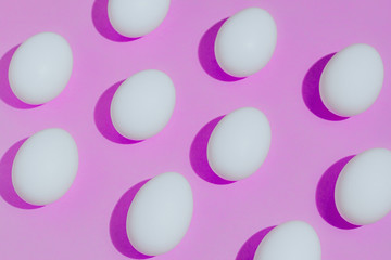 White chicken eggs  with empty space, on a pink background. Abstract image