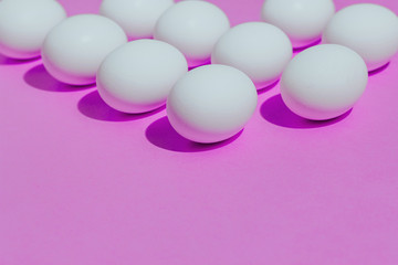 White chicken eggs  with empty space, on a pink background. Abstract image