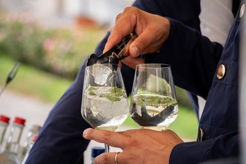 Barman is preparing a cocktail at a party
